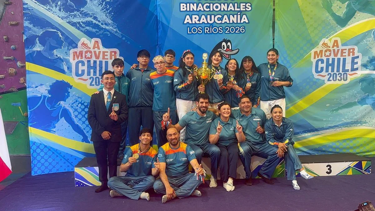 Un grupo de deportistas posa con un trofeo dorado y medallas frente a un fondo azul de Binacionales Araucanía