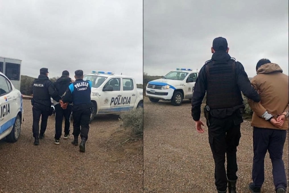 Dos hombres con las manos atadas caminan escoltados por policías frente a patrulleros en un camino de tierra